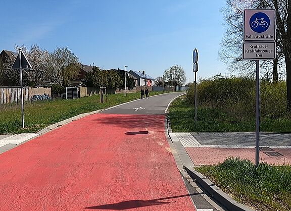 Foto einer Fahrradstraße mit roter Oberfläche und Verkehrsschild