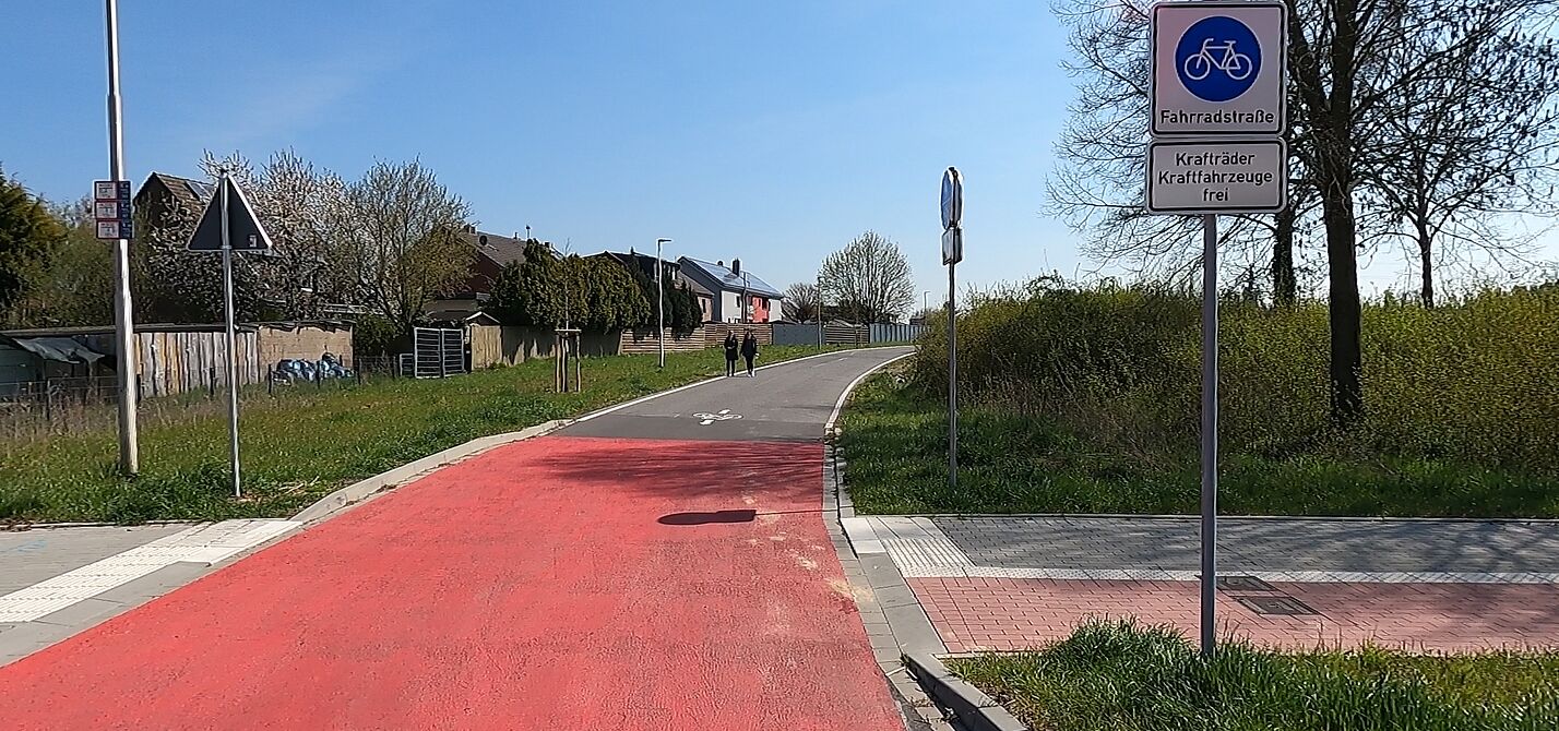 Foto einer Fahrradstraße mit roter Oberfläche und Verkehrsschild