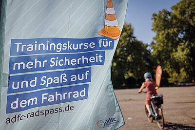 Flagge von ADFC-Radspaß mit Teilnehmerin bei Fahrübung