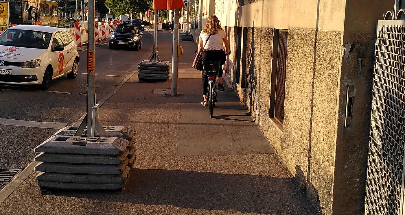 Schmaler Fuß- und Radweg mit Ampelmast