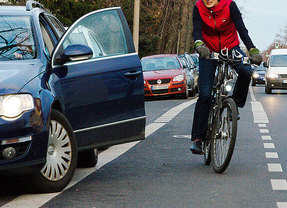 Auto Tür geöffnet, Radfahrerin weicht in Kfz Verkehr aus. 