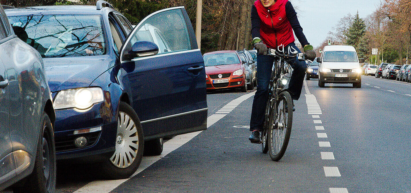Auto Tür geöffnet, Radfahrerin weicht in Kfz Verkehr aus. 