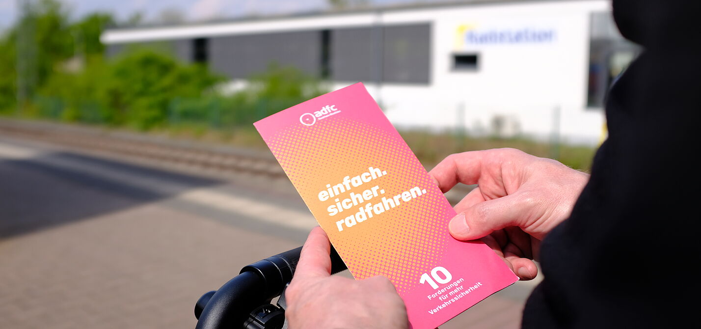2026-04-17_Dormagen_Verkehrssicherheit__ADFC_NRW Eine Person hält einen Flyer in den Händen.