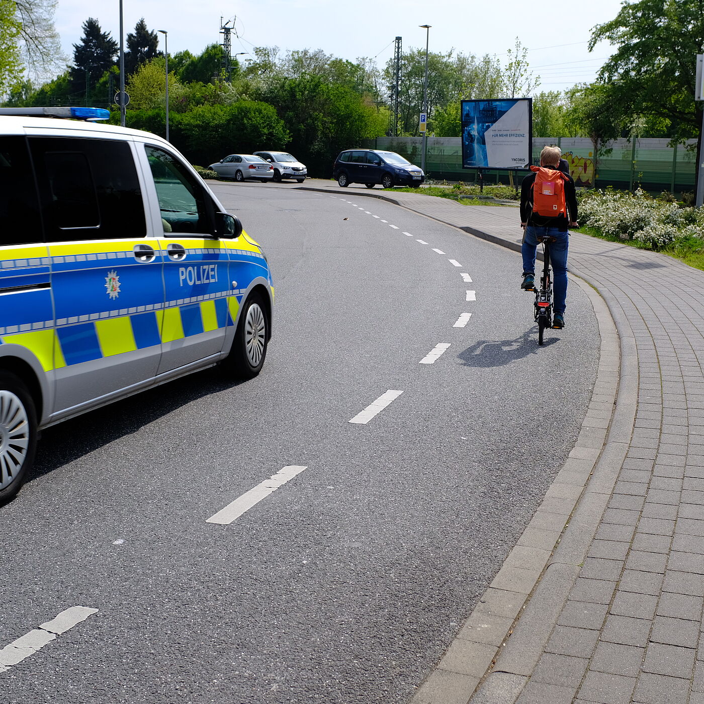 2026-04-17_Dormagen_Verkehrssicherheit__ADFC_NRW Polizei Auto und Fahrradfahrer auf Schutzsreifen.