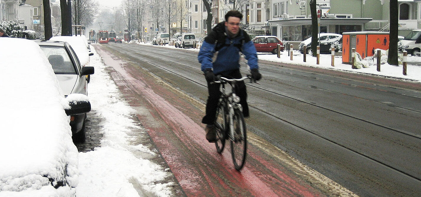 Ein leicht verschneiter Radweg.