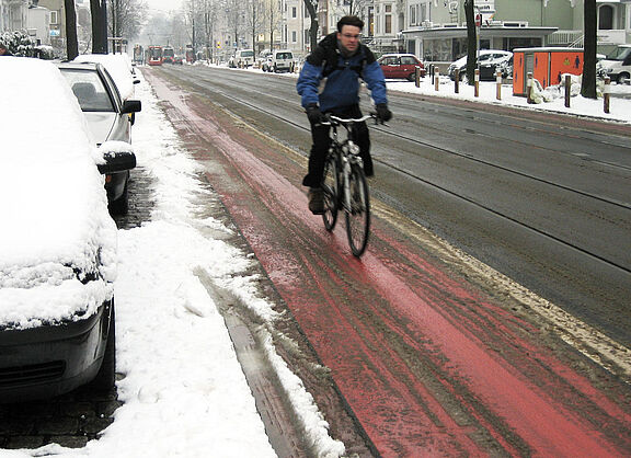 Ein leicht verschneiter Radweg.